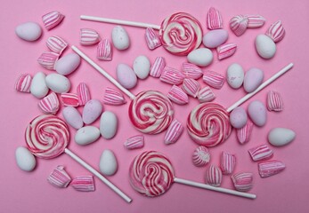 Assortment of pink and white candies on pink background