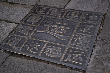 metallic tiles in the middle of a street: Luck (Yun) in Chinese culture