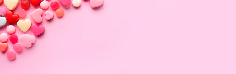 Obraz premium Heart shaped candies, flat lay, top view, empty space. Candies of different shapes on a pink background. Chewing gum for Valentine's Day