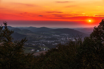 Fototapeta na wymiar Sonnenuntergang in den Bergen, während die Stadt im Tal bereits im Schatten liegt