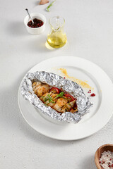 Baked fish in foil with sweet and sour sauce and fresh herbs, perfect for healthy dining and seafood recipes