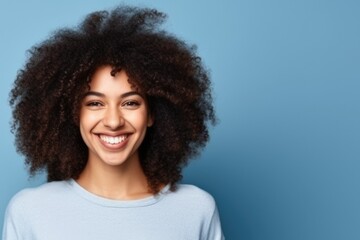 portrait of a smiling woman with curly hair on a blue background. hairdresser for curly hair. student. place for text banner