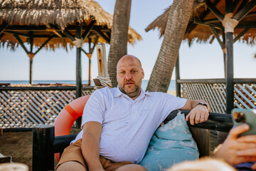 Sotogrante, Spain - January 25, 2024 - A bald man in a polka dot shirt is sitting and relaxing on a...