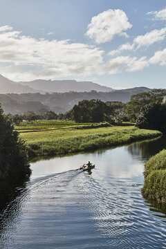 Man paddling in a canoe on Hanalei River.Hanalei, Hawaii, United States