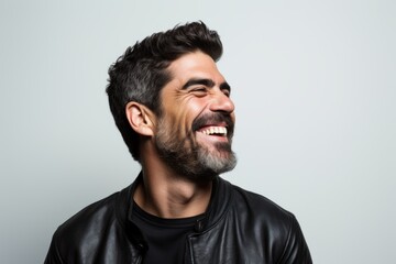 Obraz premium Handsome man with leather jacket laughing over grey background. Looking up.