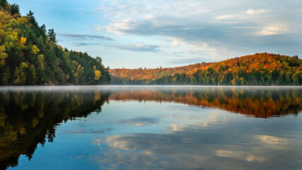 Lake and Forest in soft morning light with beautiful fall colour and reflections of the sky