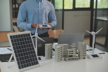 Close-up at tablet, Engineers pointing at tablet with their hands. To jointly design the use of renewable energy with wind and solar energy. Concept of using renewable energy.