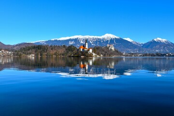 View of the church on the island at lake Bled in Slovenia in winter with a reflection in the water