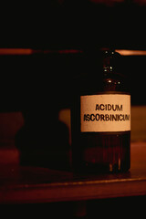 A bottle of Acidum Ascorbinicum on a shelf in darkness - 725728233