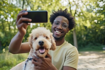 Young african american man taking selfie photo with dog on smartphone in park.