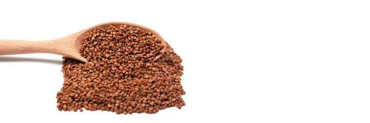 Dry buckwheat in wooden spoon isolated on white background. Banner.
