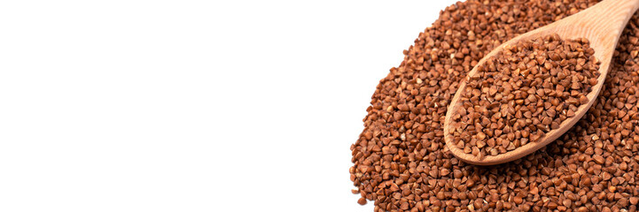 Dry buckwheat in wooden spoon isolated on white background. Banner.