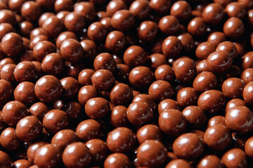 Closeup brown dragee, chocolate covered nuts, sweet candy background