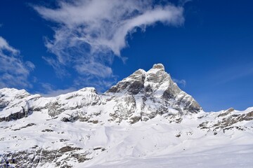 Fototapeta premium Beautiful snowcapped Matterhorn from ski slopes in Cervinia Valtournenche ski resort, Italian Alps. Snowy mountain peak that borders Italy and Switzerland.