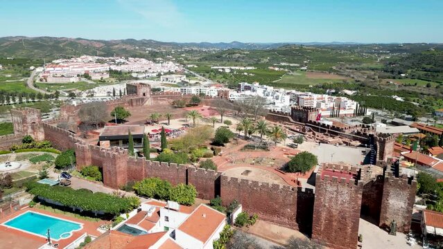 Moorish Castle of Silves, Algarve, Portugal with towers, walls, green parks, by 4K drone