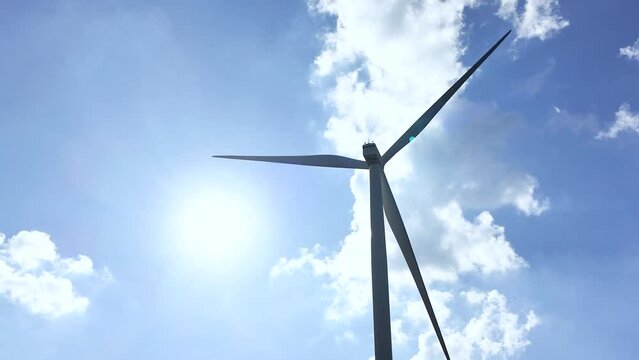 Silhouette scene of the Power turbine or windmill is using to generate electricity in blue sky and sun light as background. Renewable and clean energy technology concept. 4k footage.