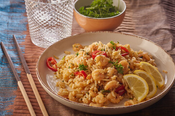 Spicy prawns stir fry with rice and garnished with herbs.