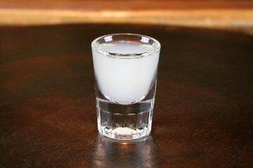 Ouzo or raki - traditional balkan anise strong alcoholic drink on bar counter close-up.