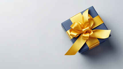 gift box in the form of a cubic gray box with a gold ribbon on a light gray background