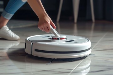 A person is using a robotic vacuum cleaner to clean the floor. This image can be used to depict household chores and modern cleaning technology