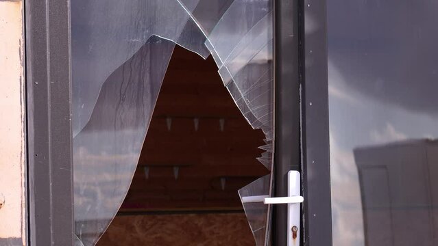 Broken glass in door or window on city street. Vandalism or theft from apartment, house or shop. Street riots. Bandis robbed store. Elements and strong hurricane with wind damaged facade of building.