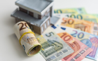 Model of cardboard house with key and dollar bills. Building, loan, real estate, cost of housing or buying a home concept.