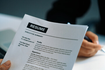 Human resources department manager reads CV resume document of an employee candidate at interview...