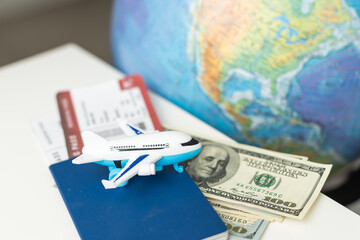 Toy airplane, globe and passport on a blue background