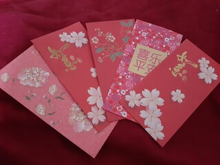 four chinese style red envelopes with gold foil designs on them