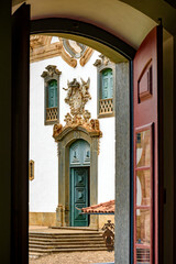 Baroque church front seen through the window of an old colonial-style house in the city of Mariana in Minas Gerais
