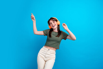 Photo of pretty carefree person closed eyes point fingers dance listen music isolated on blue color background