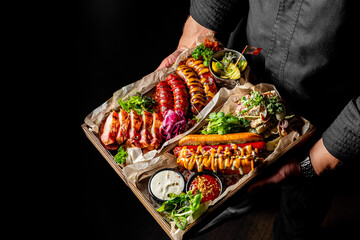 chef or waiter hold Set with various meat Bavarian, Frankfurt, German grilled sausages
