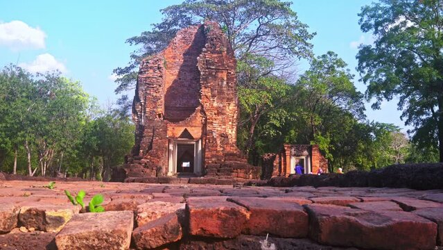 The ruins of an old castle built with laterite bricks of the ancient city of Si Thep..Ancient Angkor Temple Tower Amidst Park's Historic Stone Ruins and Towering Trees .in Si Thep Historical Park.