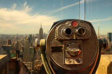 A close-up of coin-operated viewing binoculars invites onlookers to take in the expansive New York...
