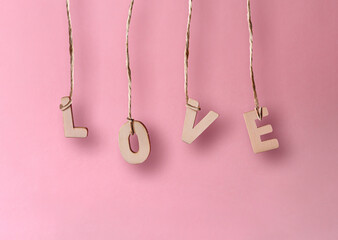 Wooden letters forming the word love held with jute thread