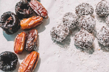 Healthy vegan sweets made from dates and prunes, cocoa and nuts in coconut flakes. Raw vegetarian sweets. Sugar free, gluten free.