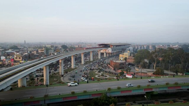 Drone following the metro train while flying over a highway