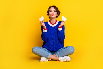 Full length photo of pretty flirty lady dressed knitted sweater holding white hearts sending you kiss isolated yellow color background - obrazy, fototapety, plakaty