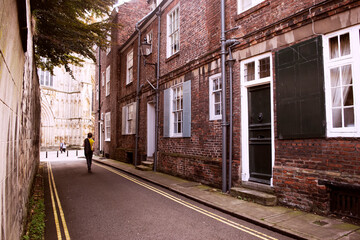 Solitary Stroll through Medieval York: Red Brick Houses, White Windows, Lonely Figure – Nostalgic Urban Loneliness