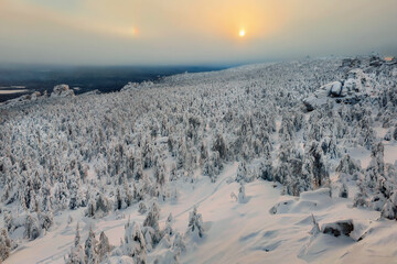 Mystical dawn in the winter. Mountain path through a snowy forest.