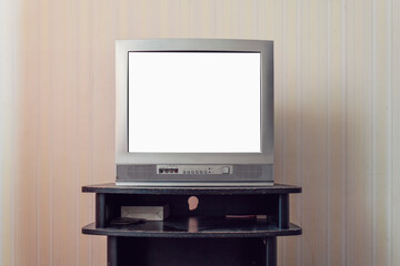 Blank white tv screen with mockup space in room with retro wallpaper in apartment or hotel