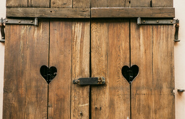 Old wooden Window shutters with hearts. Sad Valentine, lost love, love end, relations crisis,...
