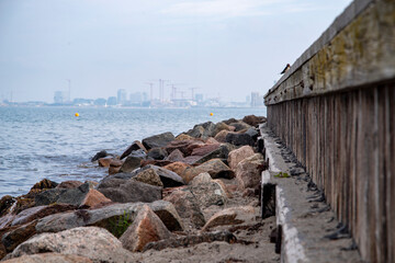 Wellenbrecher an der dänischen Küste mit der Stadt Kopenhagen im Hintergrund.