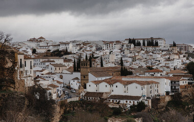 "Whitewashed houses of Ronda, Spain, under moody skies"