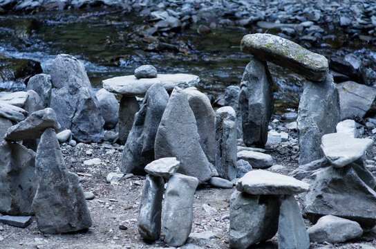 Gray stones, large and small, near the river. The stones are stacked on top of each other.