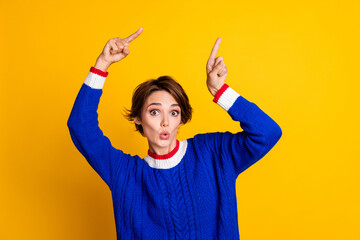 Photo portrait of attractive young woman point shocked empty space wear trendy blue knitwear clothes isolated on yellow color background - obrazy, fototapety, plakaty