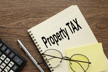 Property tax symbol. glasses lie on a notepad near the calculator. text. Business and property tax concept. Copy space.