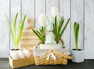 Decorative Easter composition on a wooden background wicker basket with spring flowers hyacinths...