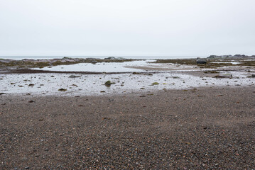 A beach of l’isle verte a cloudy spring day (Notre-Dame-des-Sept-Douleurs, L’Isle-Verte, Quebec, Canada)
