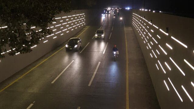 Traffic vehicles going into under pass, recently renovated with lights in Lahore, Pakistan. 
